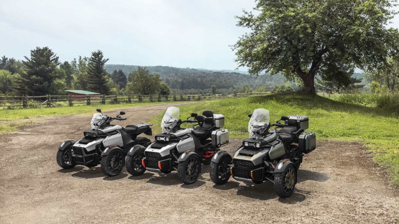 Trois Can-Am Canyon 3-roues garés devant un paysage de campagne